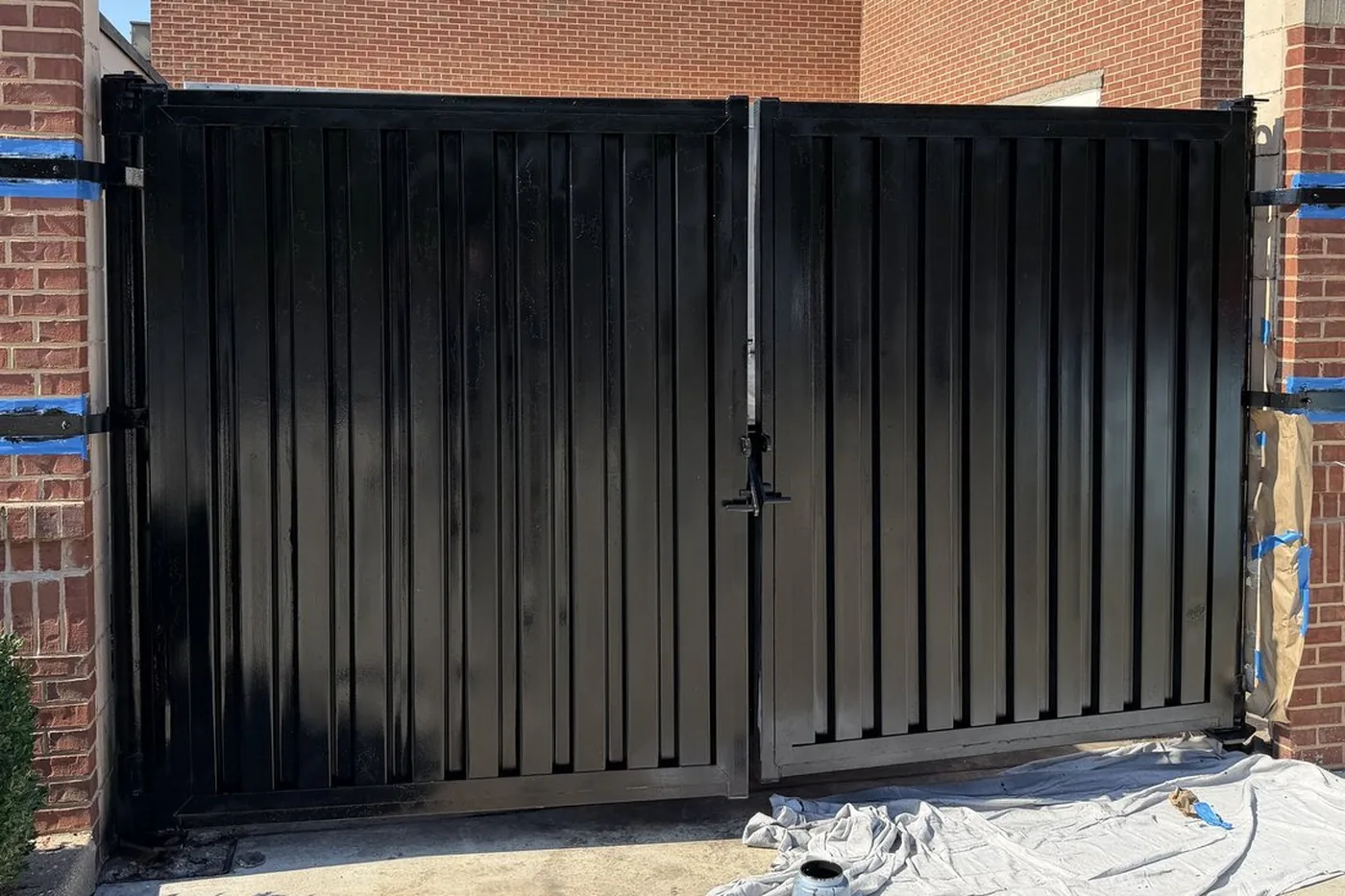 After: the same gates refinished in gloss black