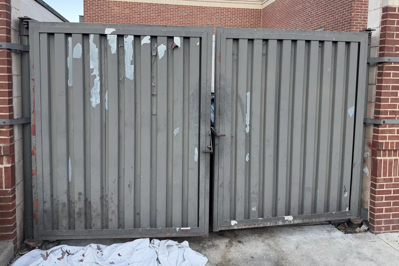 Before: gray enclosure gates with peeling paint