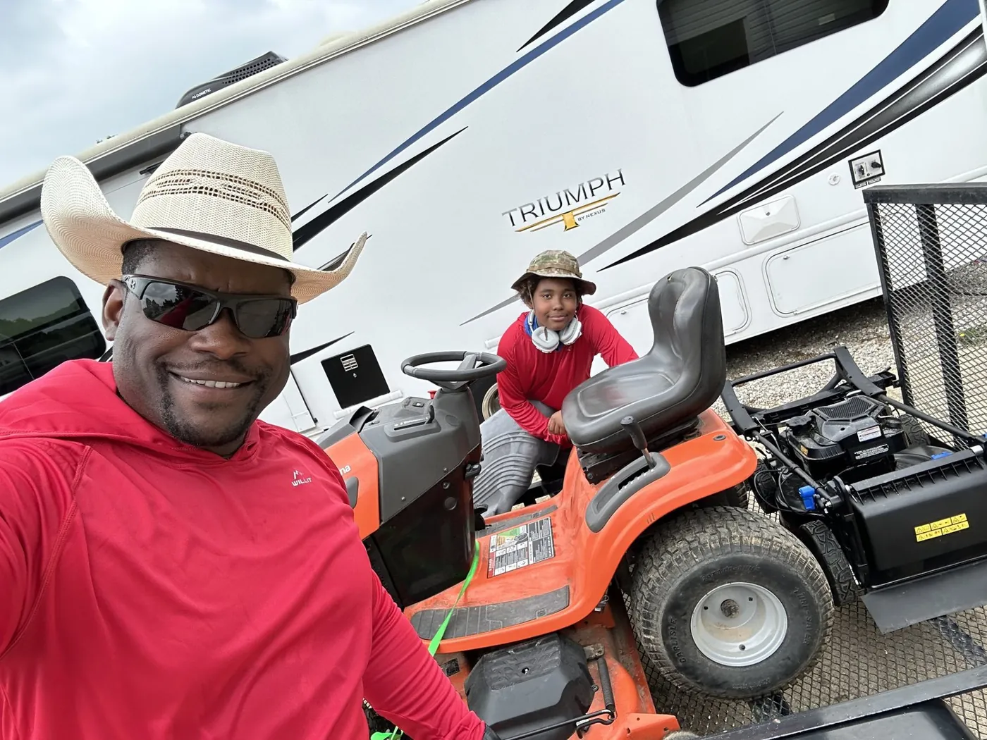 Eric Fikes and his son with the mower loaded on the trailer